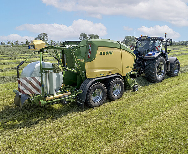 Пресс-подборщик управляет трактором